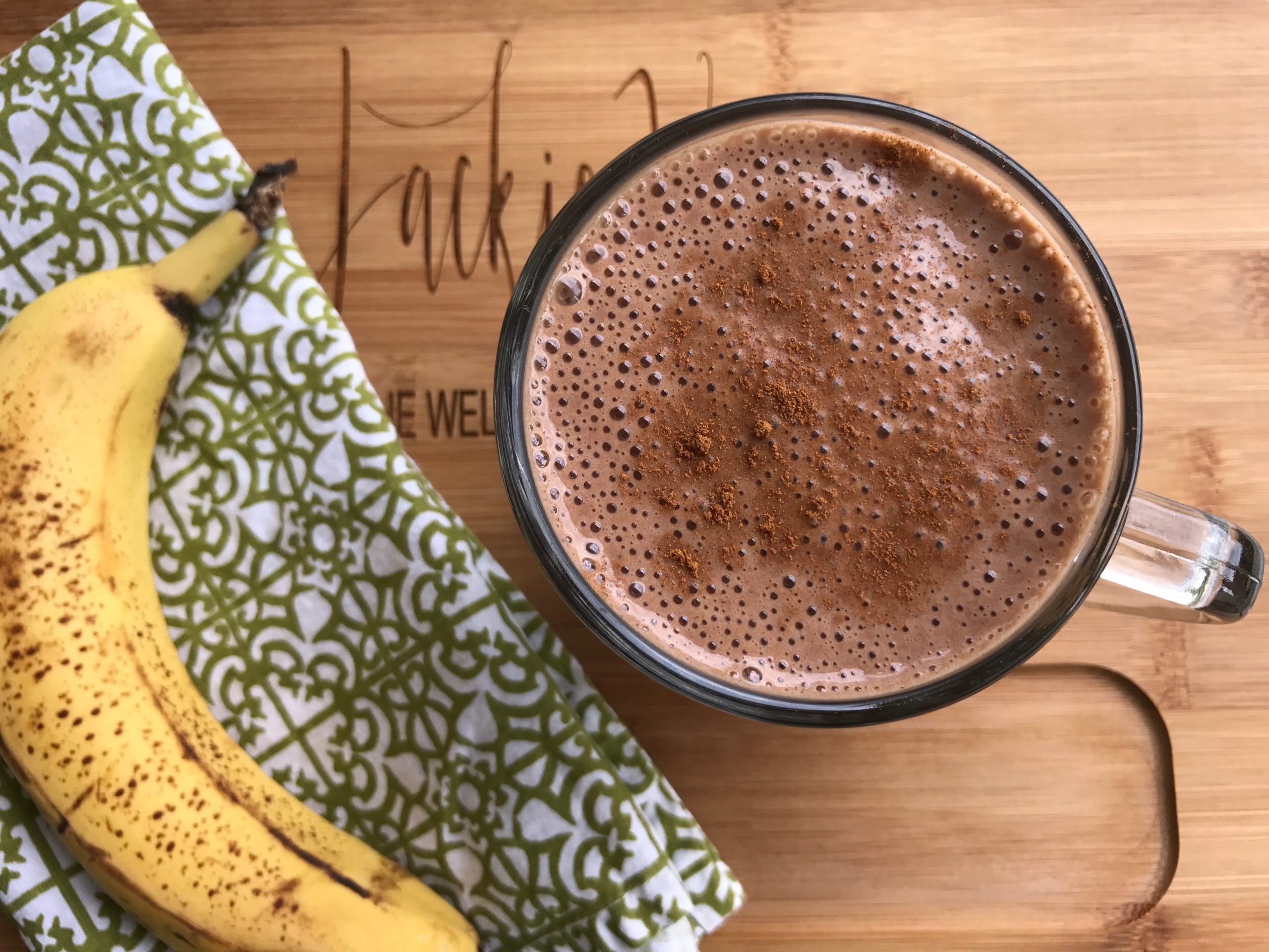 hot cocoa smoothie on wood cutting board with banana